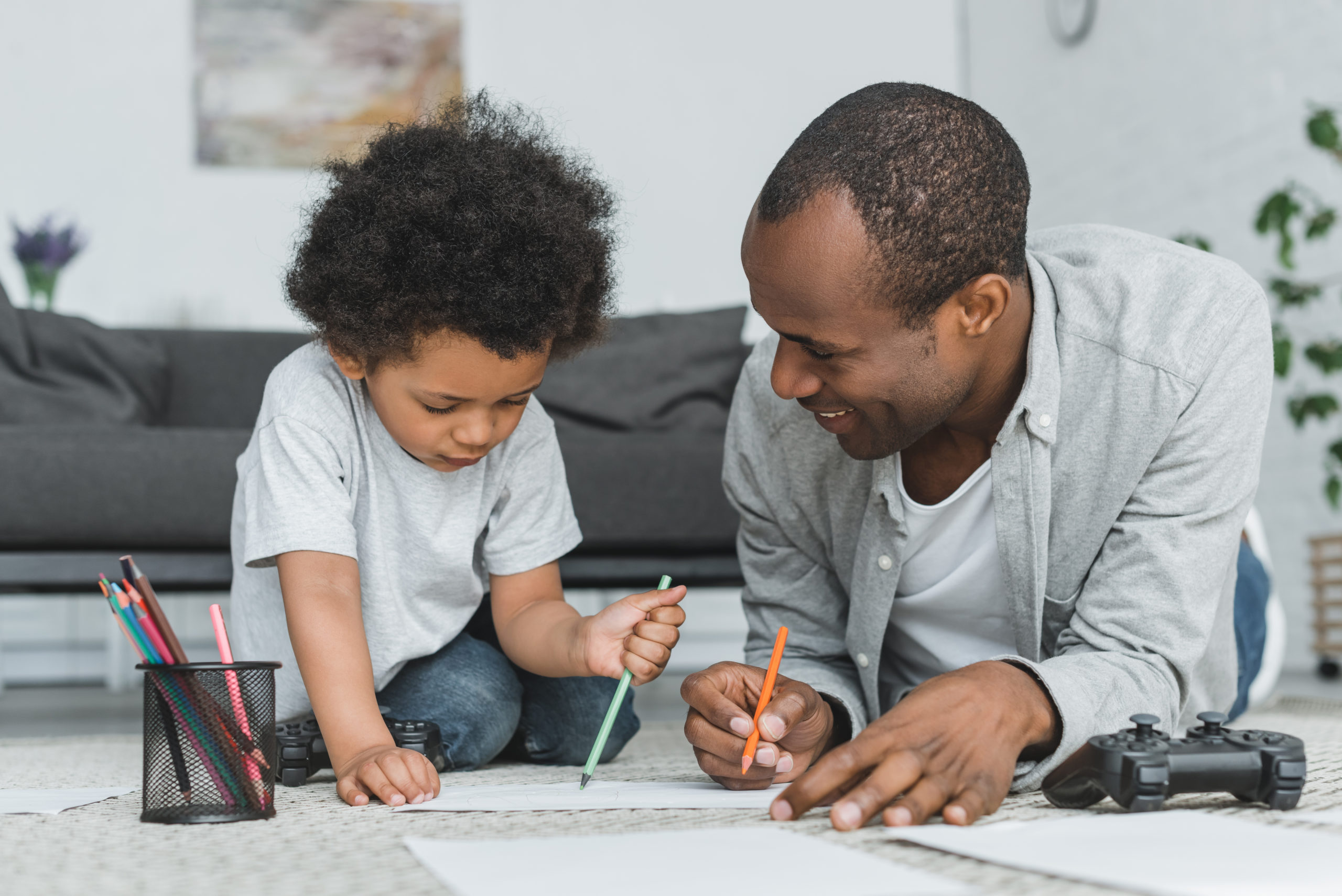 African,American,Father,Drawing,With,Son,On,Floor,At,Home